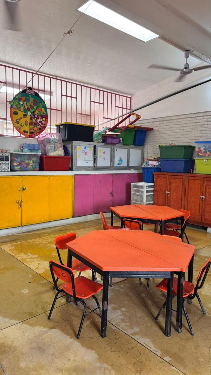 Aula con mesas hexagonales, materiales didácticos y rueda de nutrición