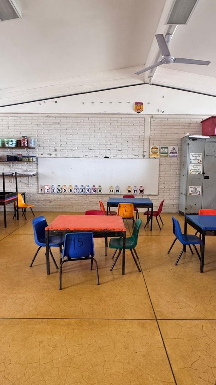 Aula con pizarrón, números del uno al dieciocho y mesas de trabajo